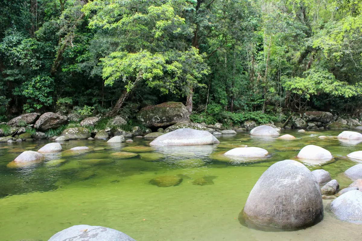 Air sungai hijau jernih dengan batu-batu bulat